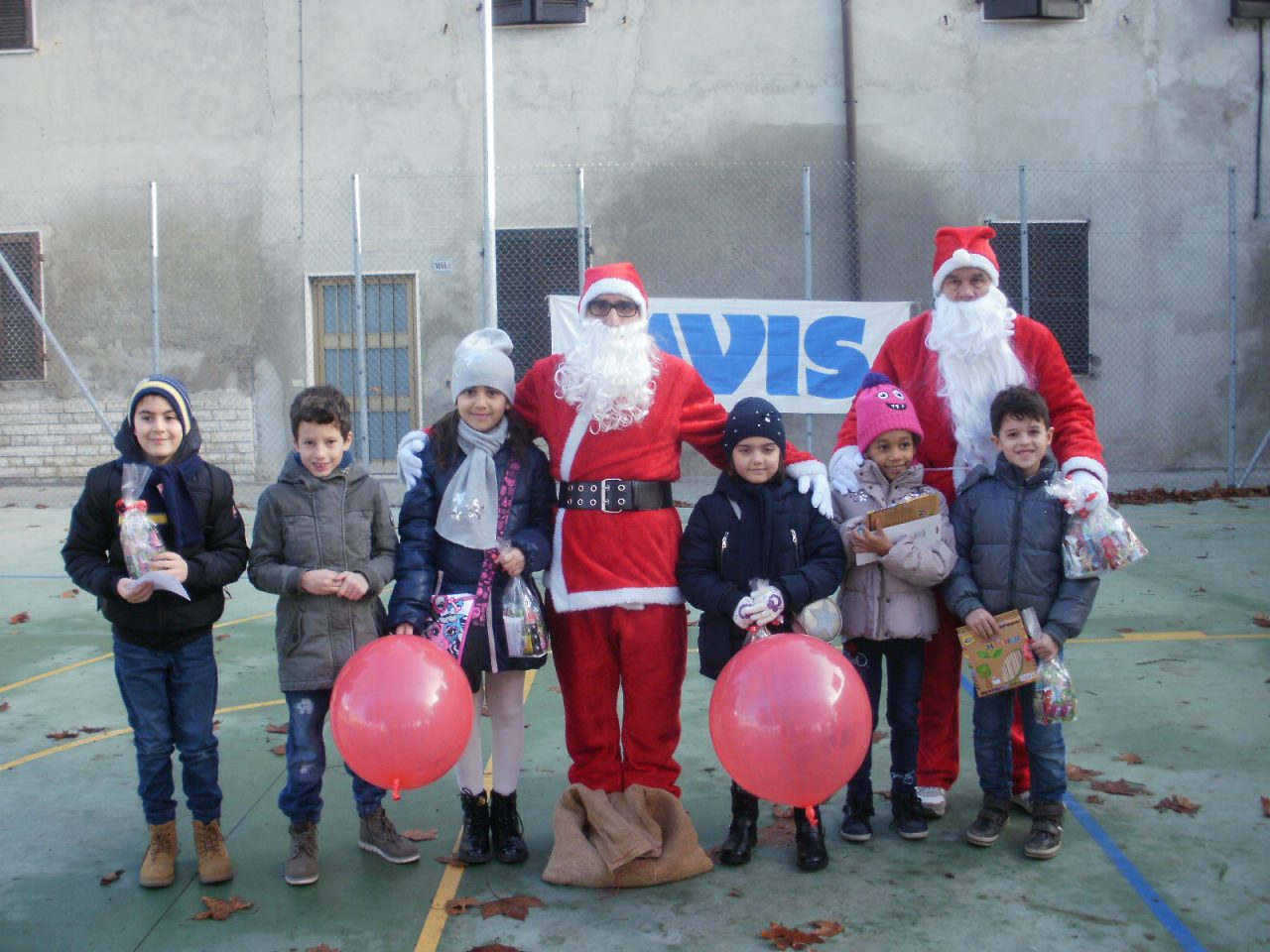 Babbi Natale Avis e Aido regalano dolci e matite ai bimbi