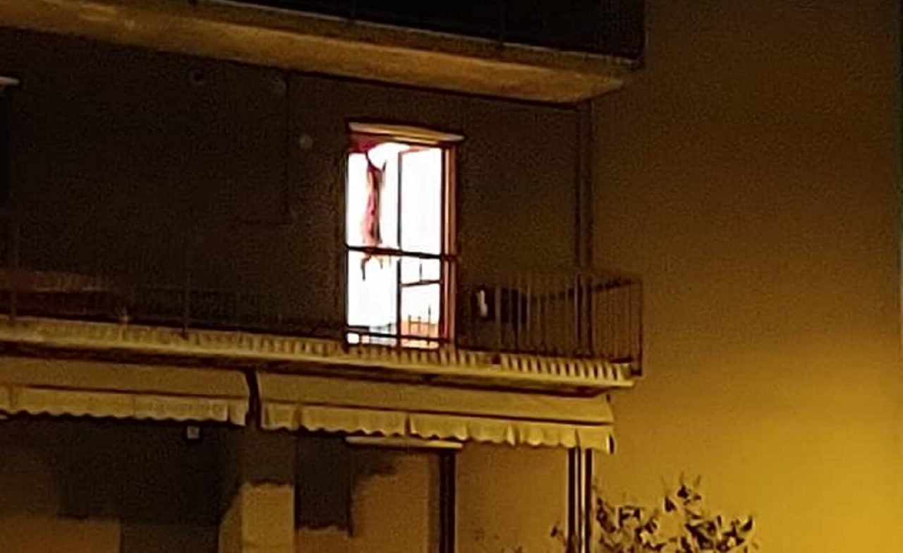 Capra macellata appesa sul balcone di casa