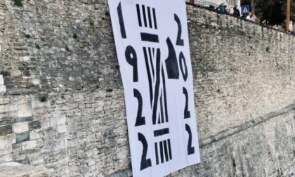 Dalle mura di Bergamo penzola uno striscione che celebra la marcia su Roma