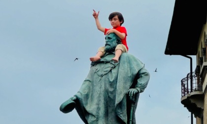 Un bimbo sulle spalle della statua di Garibaldi alla Rotonda dei Mille: è un’opera di Cattelan